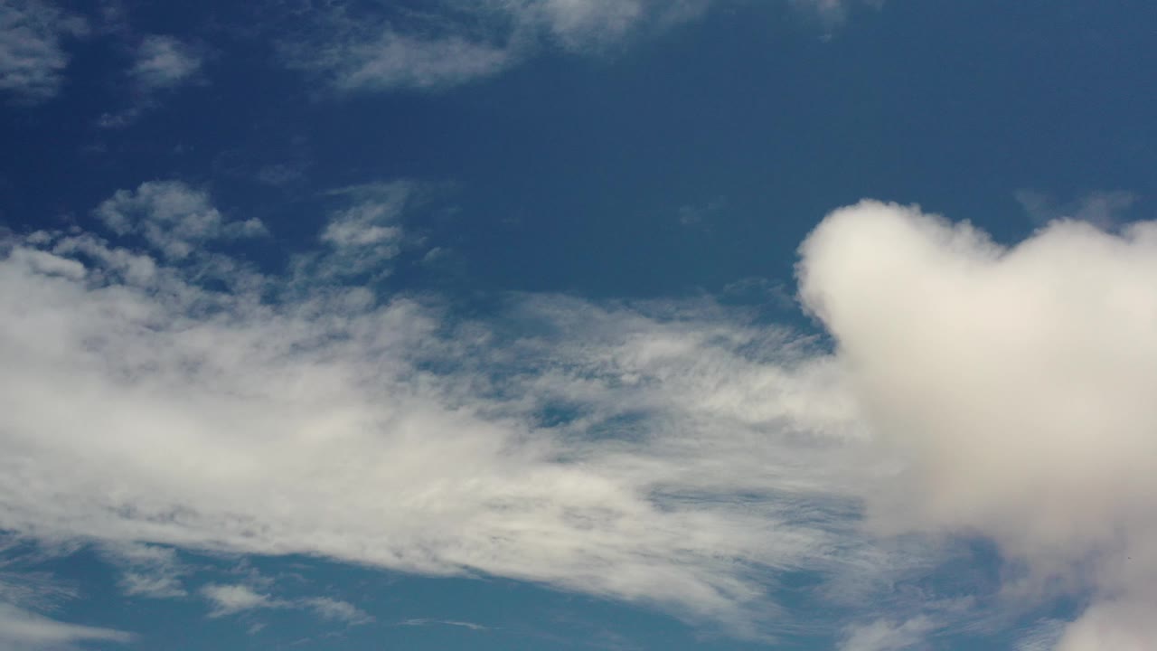 Blue sky with layered white cloud streaks.