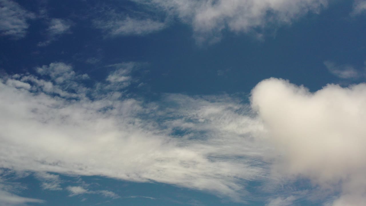 At 0:00, broad white clouds spread across a deep blue Los Cabos sky with no visible people, buildings, or horizon.