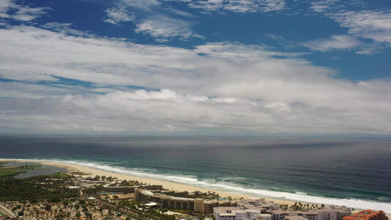 Ocean horizon above a beach and developed shoreline.