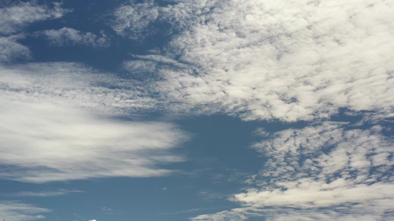 Opening frame of a Los Cabos, Mexico sky view with broad white cloud layers across blue daylight and no visible people.