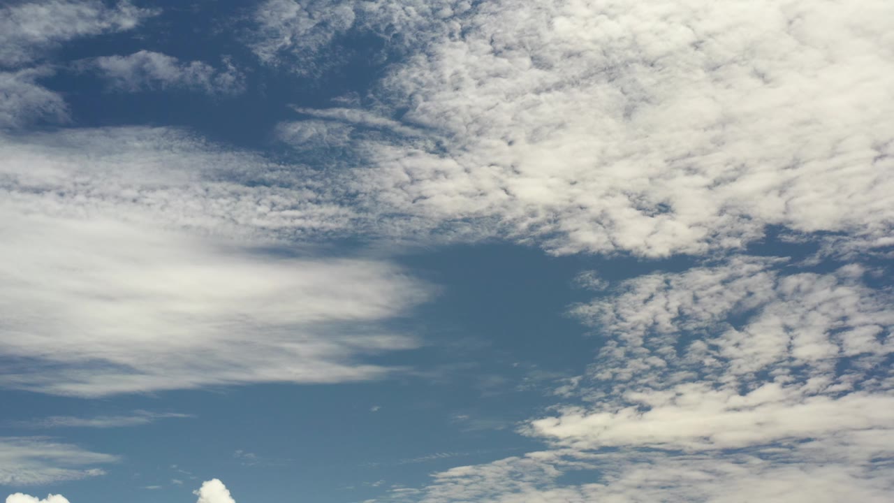 Blue sky with dense white clouds along the top and right side.