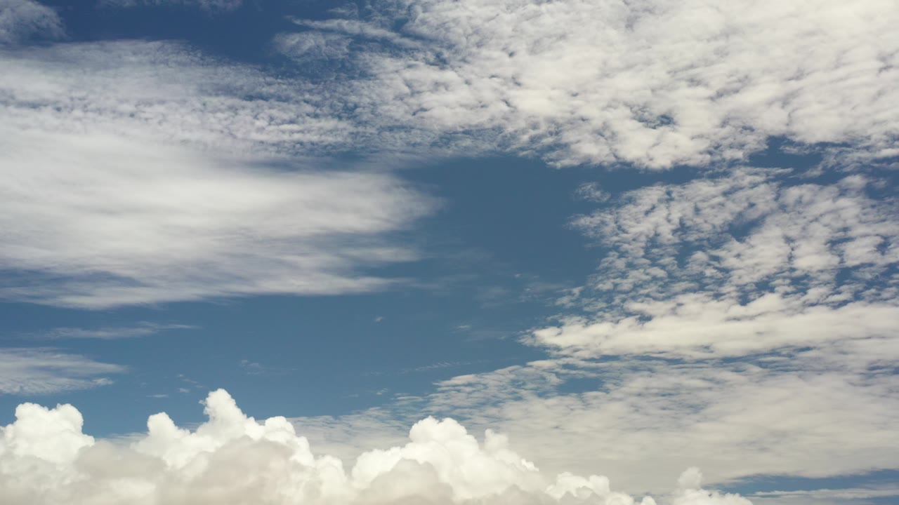 Blue sky over Los Cabos, Mexico with high streaked clouds above a low band of white cumulus, no visible people.