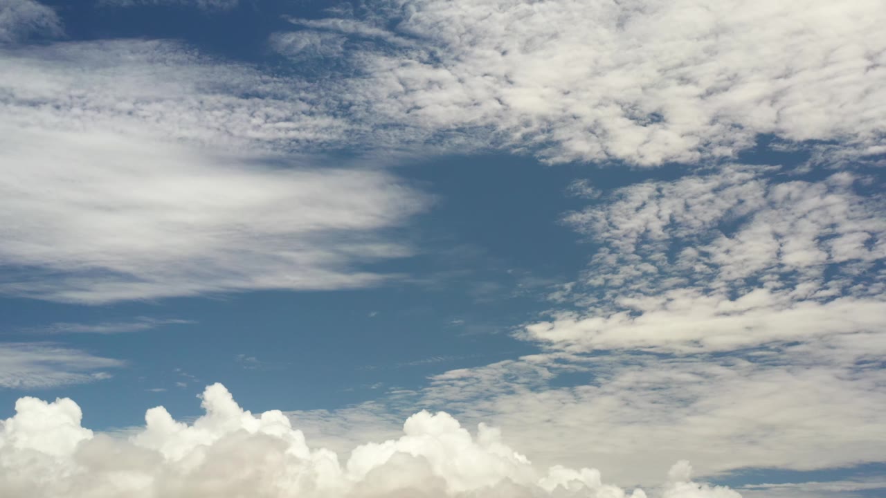 Los Cabos daytime sky with bright cumulus clouds along the bottom edge and thin cloud texture overhead, no visible people.