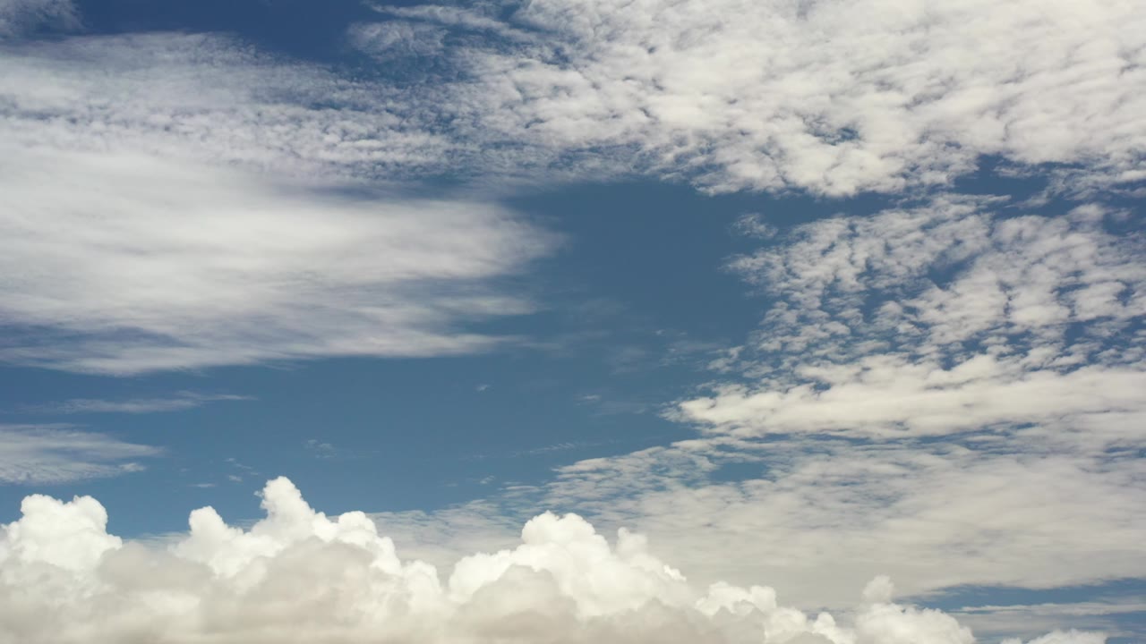 Cumulus clouds below streaked cloud cover