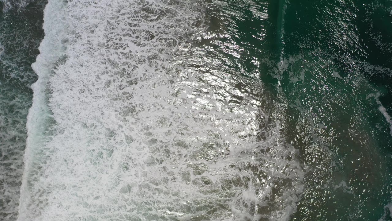 A white foamy wave line runs through dark green-blue water in Los Cabos, Mexico, with no visible people or objects.