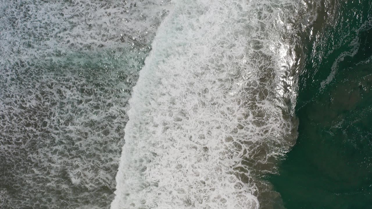 Overhead surf bands and dark green ocean water.