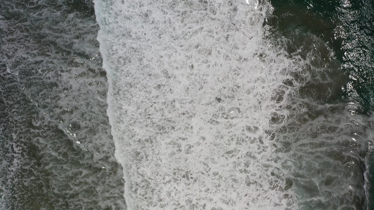 Overhead white surf breaking over dark ocean water