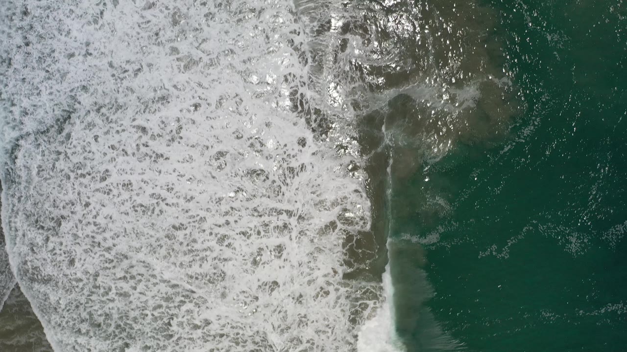 White surf pattern over dark green water.