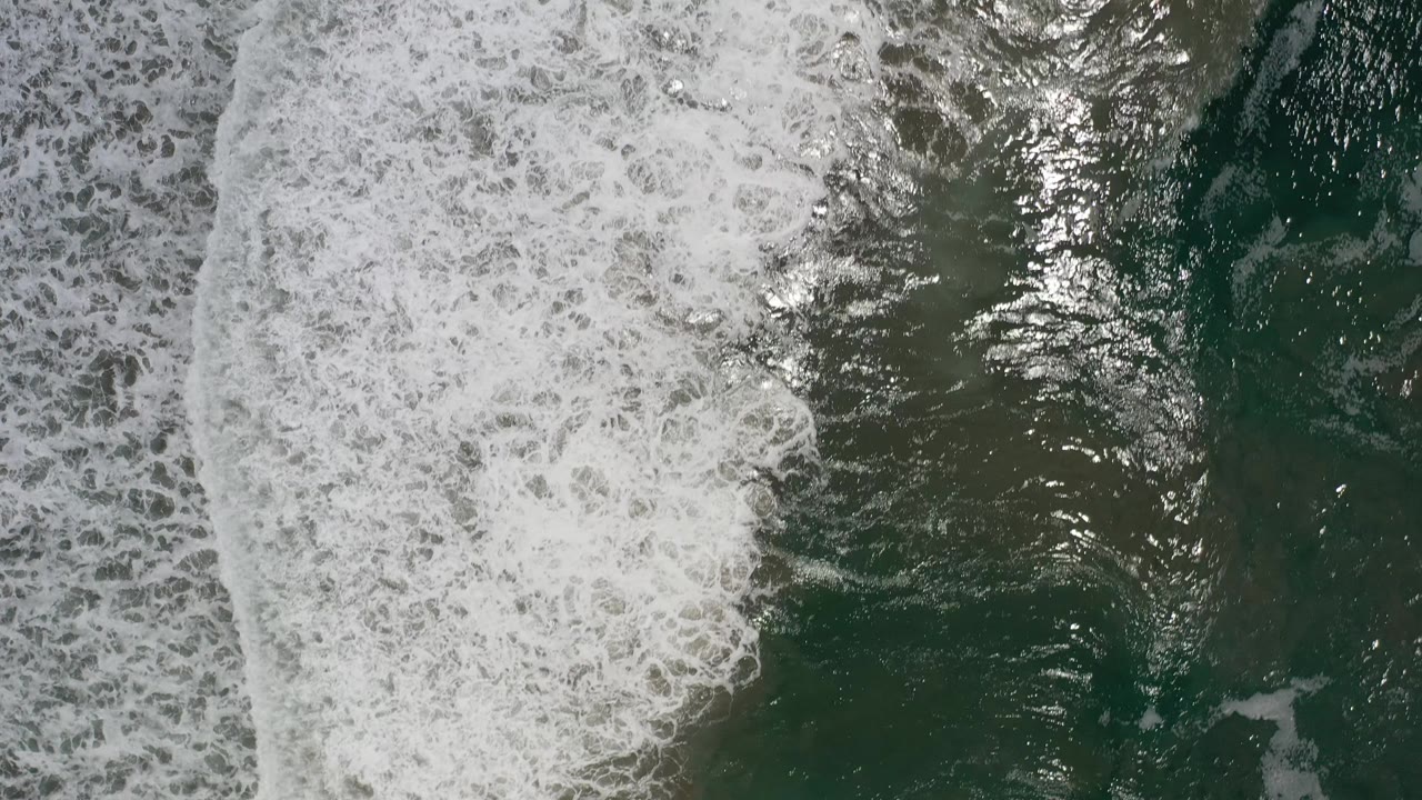 Foamy surf pattern over green water