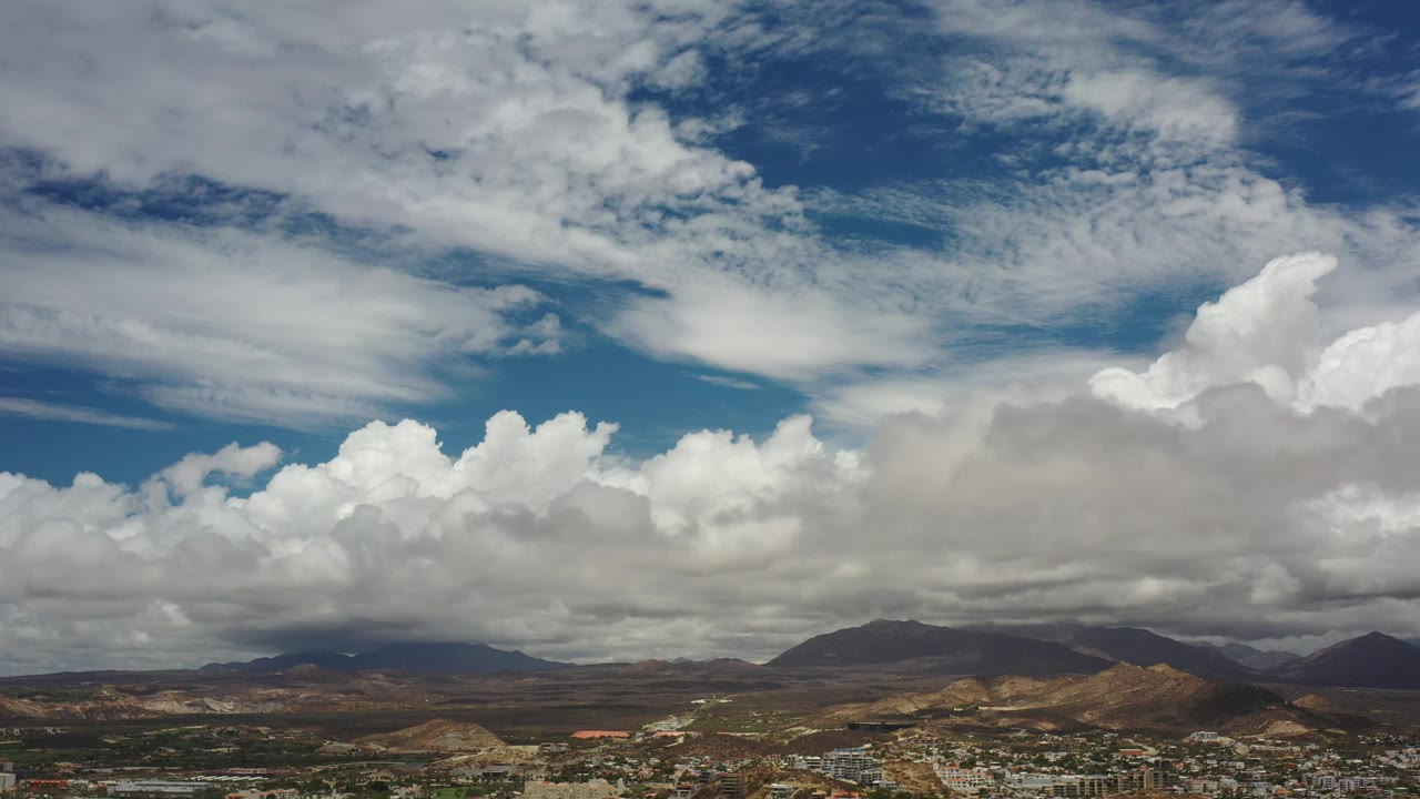 Expansive sky over mountains and desert terrain.