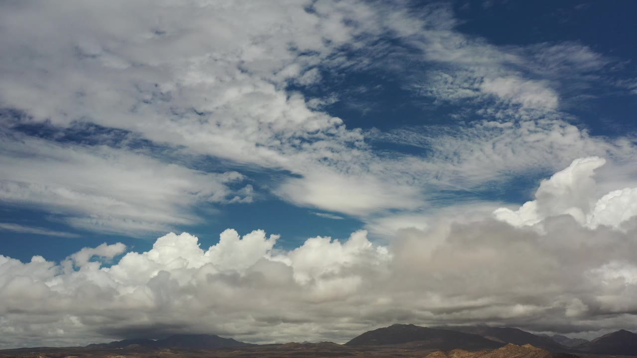 Large cloud bank over distant mountain ridges.