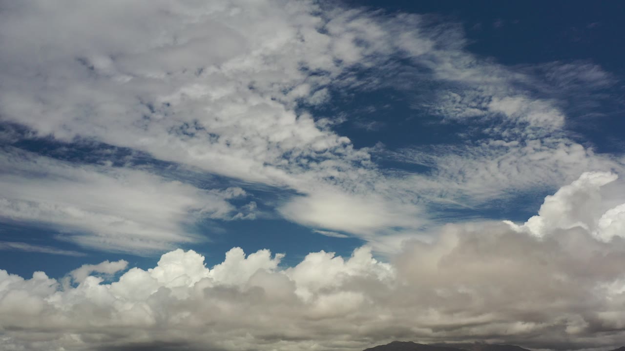 Cloud-filled sky over distant low mountains
