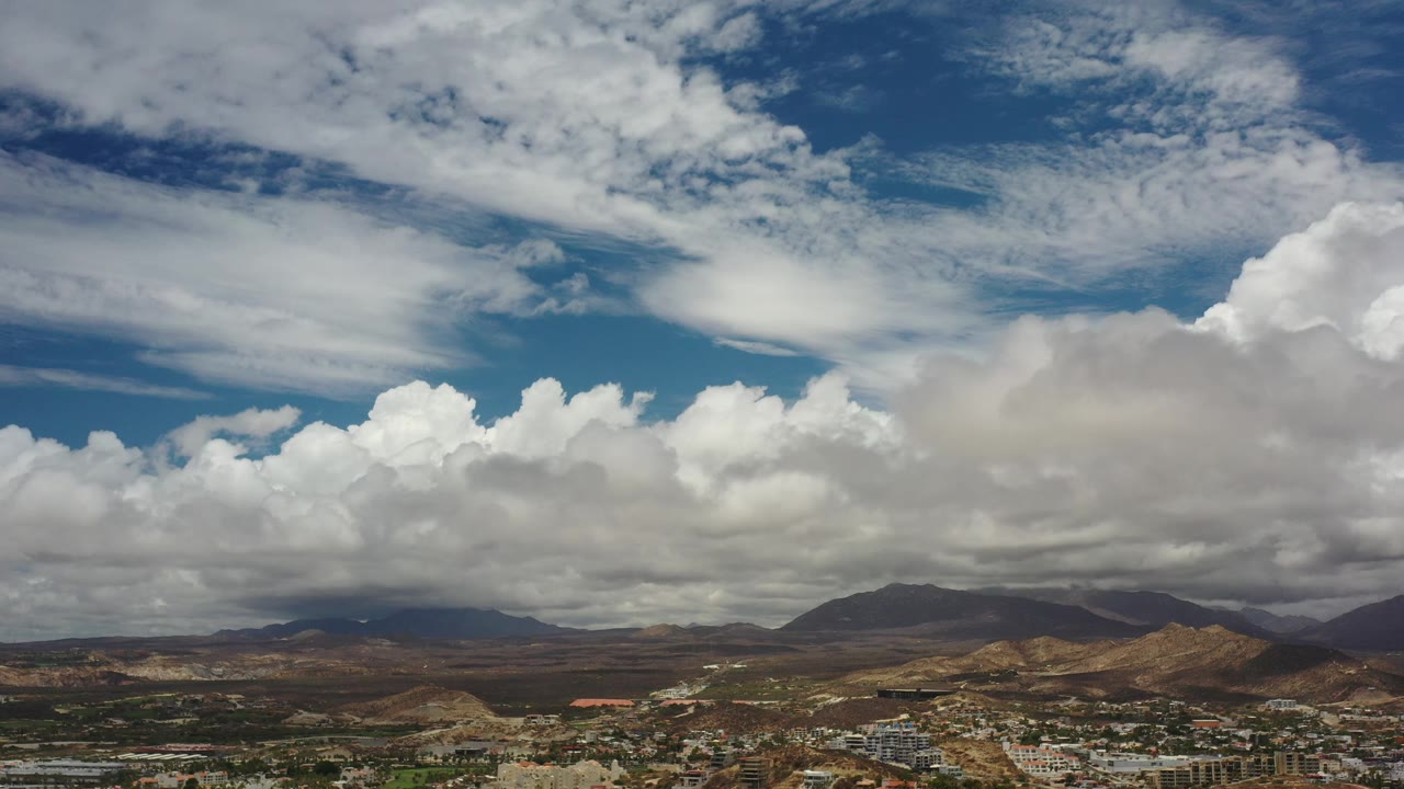 Distant mountains under large white and gray clouds.