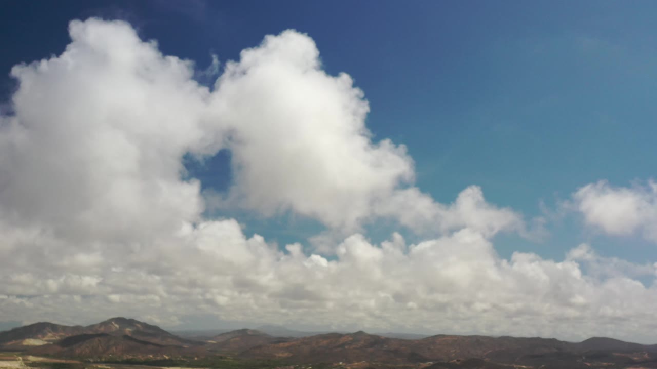 Bright cloud clusters over brown hills