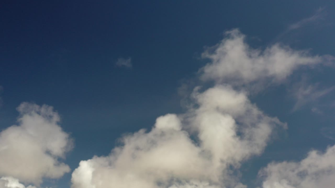 Opening frame of the Los Cabos, Mexico clip, with soft white clouds along the lower edge beneath a deep blue sky and no visible people.