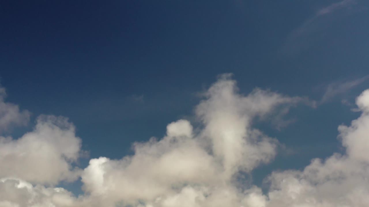 Early frame showing billowing white clouds under a broad blue sky in Los Cabos, with no visible people.