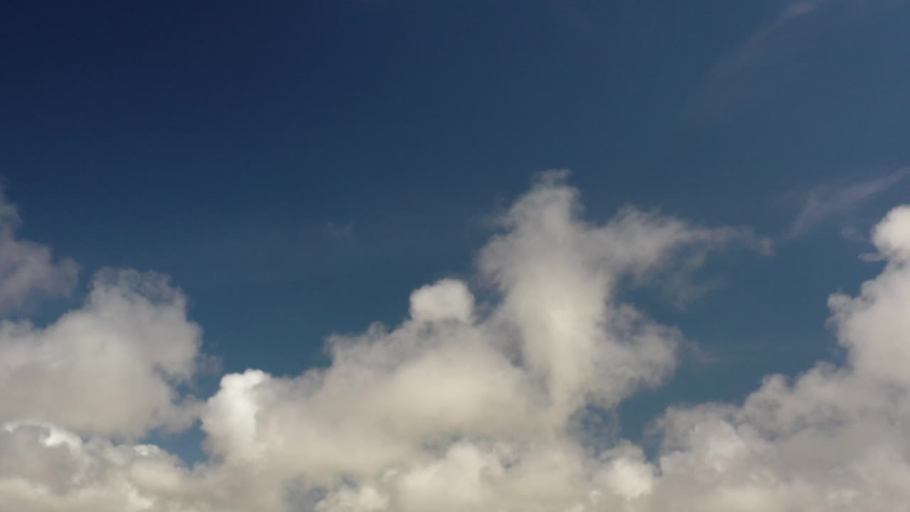 Bright cloud cluster against dark blue sky.