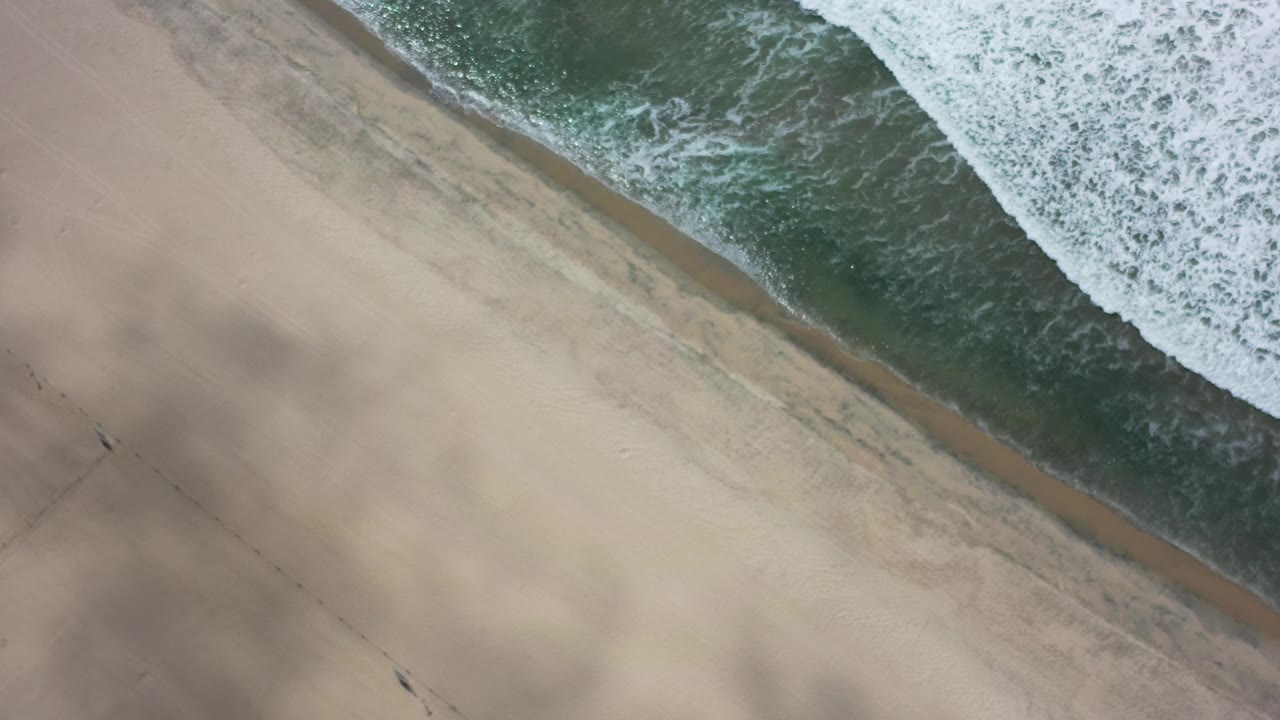 Aerial surf line with shadowed sand below