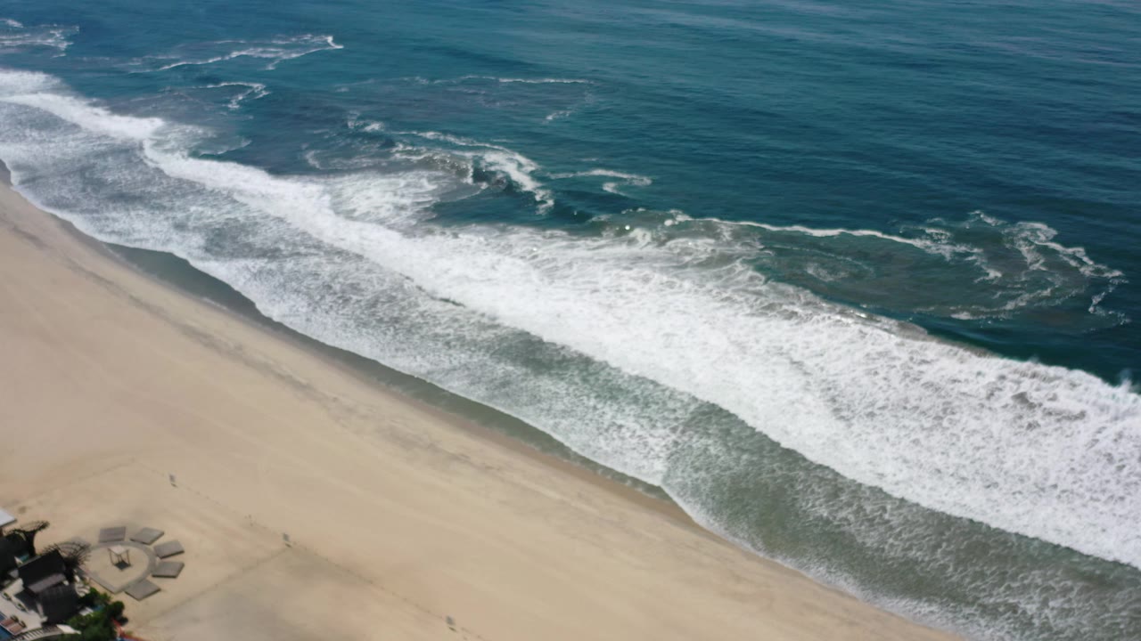 Aerial shoreline with white waves and blue water