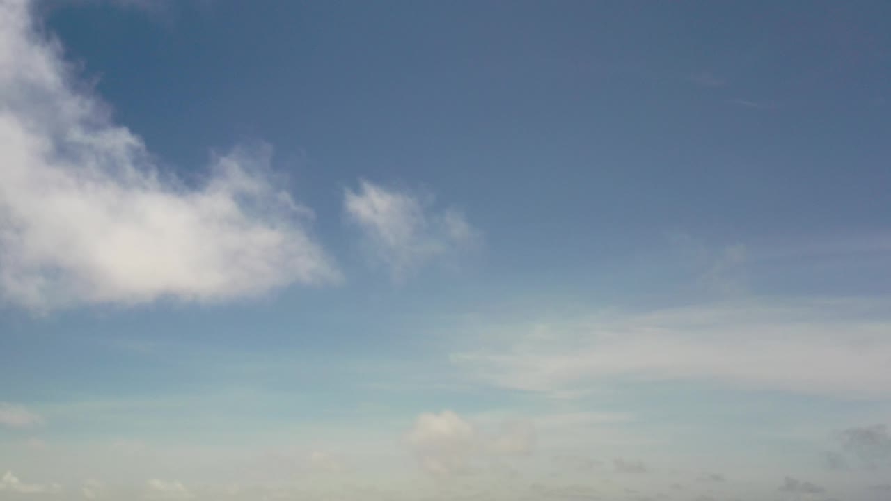 Blue sky with bright cloud at upper left and faint cloud near the lower center.