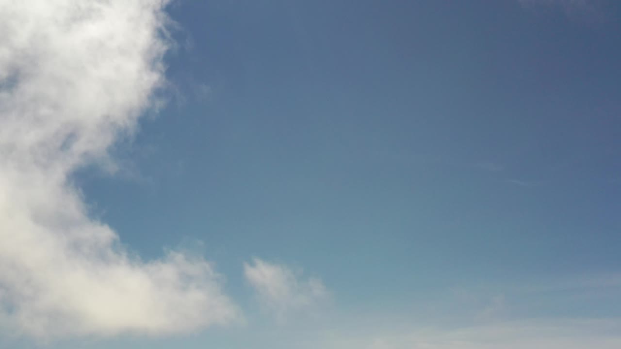 Bright blue sky with white cloud cover near the upper left.