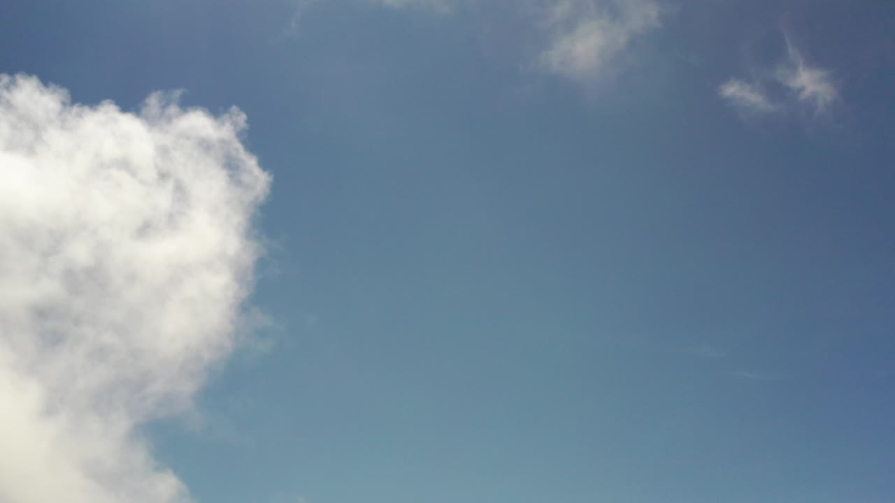 Blue sky with a white cloud on the left and faint clouds near the top.