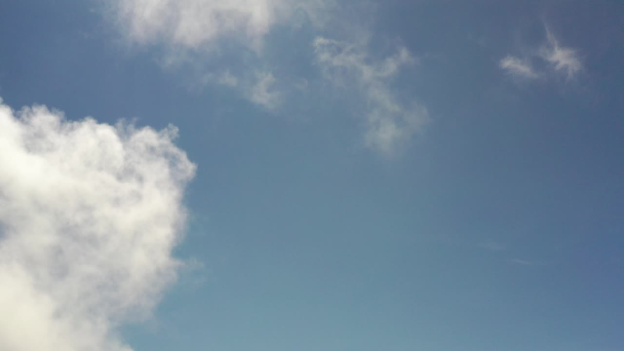 Blue sky with white clouds along the left edge