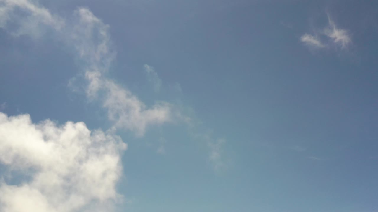 At 0:01, the Los Cabos Mexico sky frame holds a bright cloud bank at the lower left with thin scattered cloud strands across the upper sky and no visible people.