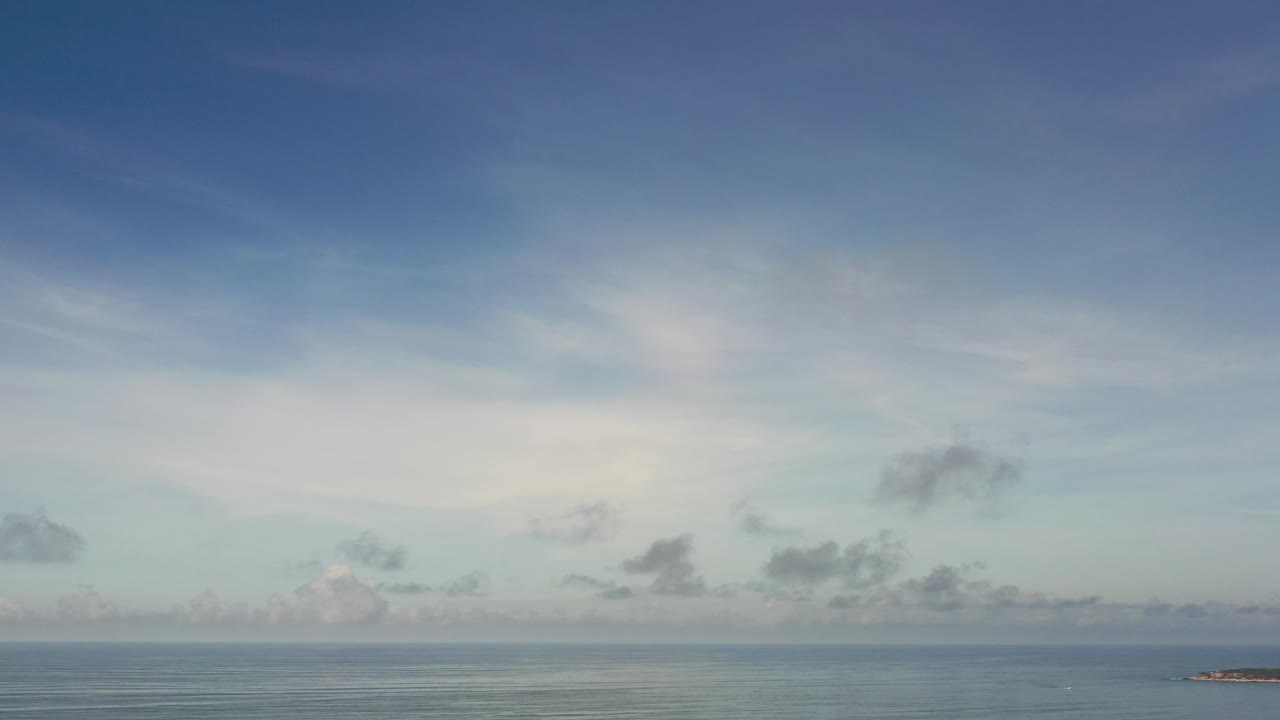 Opening frame of a Los Cabos, Mexico sky over a flat ocean horizon, with pale clouds spread across the upper frame and no visible people.