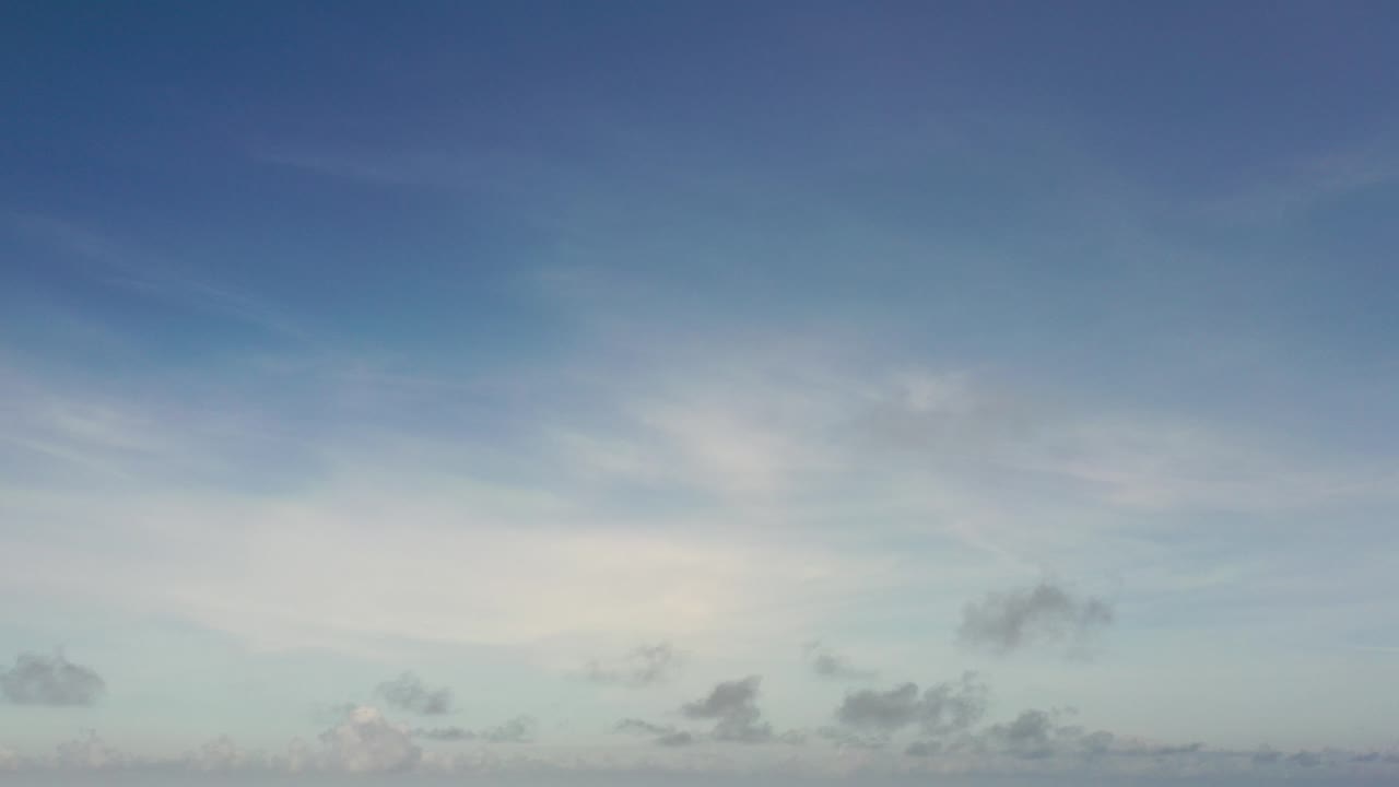 Opening frame of a Los Cabos, Mexico sky view with deep blue overhead color, a pale cloud band low in frame, and no visible people.
