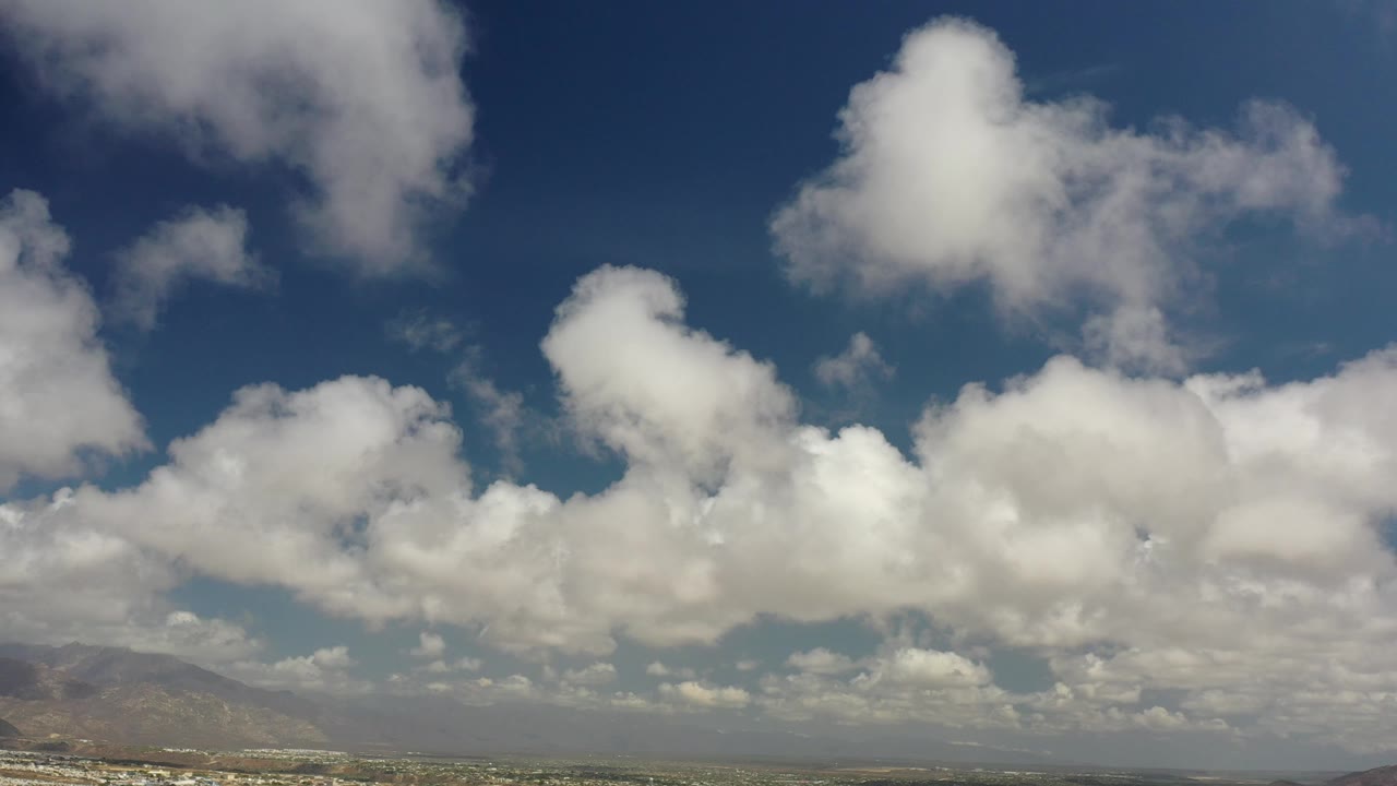 Cloud-filled sky over coastal mountains