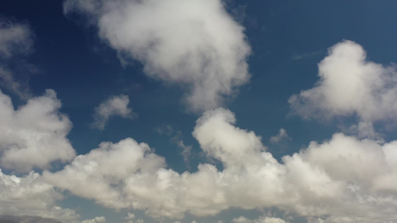 White clouds in a blue daytime sky.