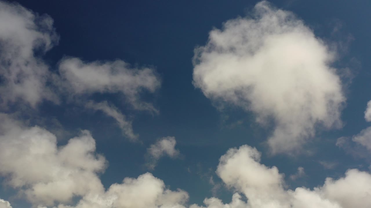Opening frame from Los Cabos, Mexico, showing white clouds spread across a deep blue sky with no visible people.