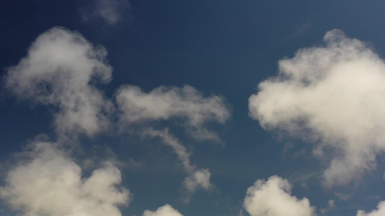 Los Cabos sky frame with a large soft cloud near the upper left, smaller wisps across the center, and no visible people.
