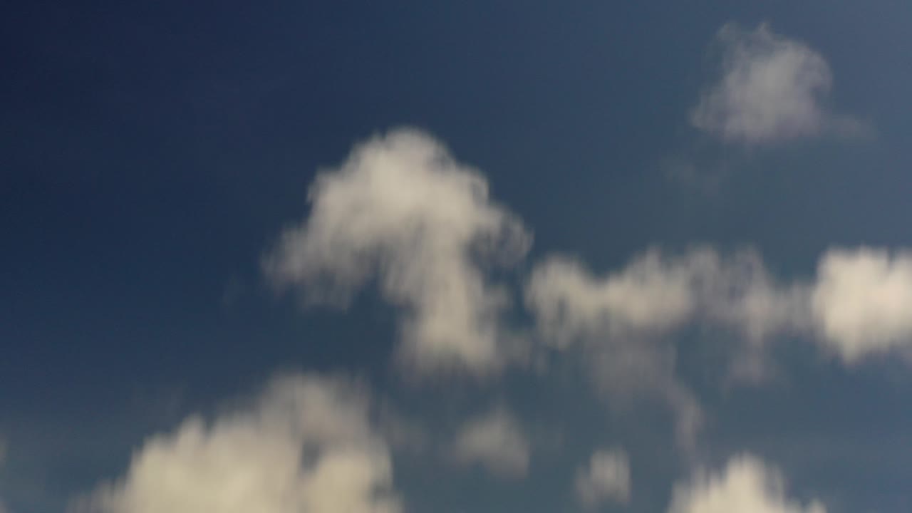 At 0:00, white clouds cross a dark blue Los Cabos sky with no ground, buildings, or visible people.
