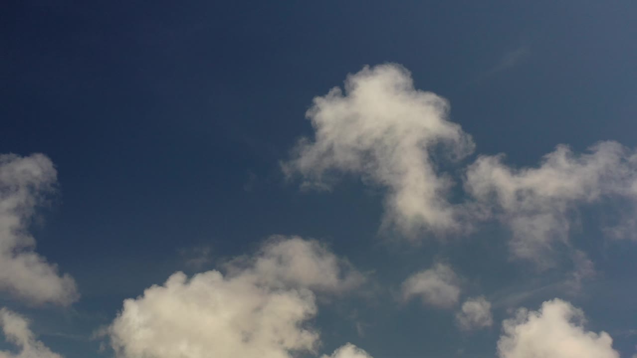 Cumulus clouds against dark blue sky