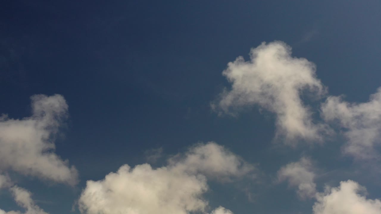 Opening frame of white clouds crossing a dark blue Los Cabos, Mexico sky with no visible people, buildings, or horizon.
