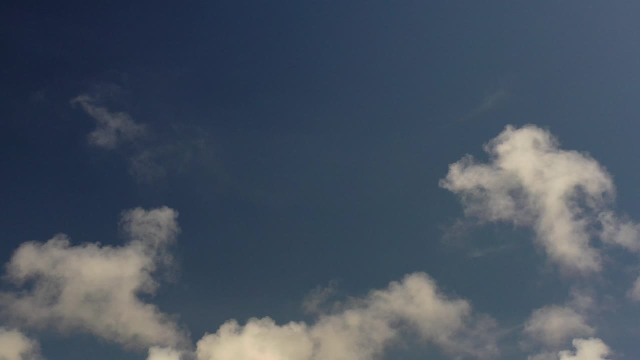 Opening frame of the Los Cabos clip showing deep blue sky, white clouds along the lower edge, and no visible people.