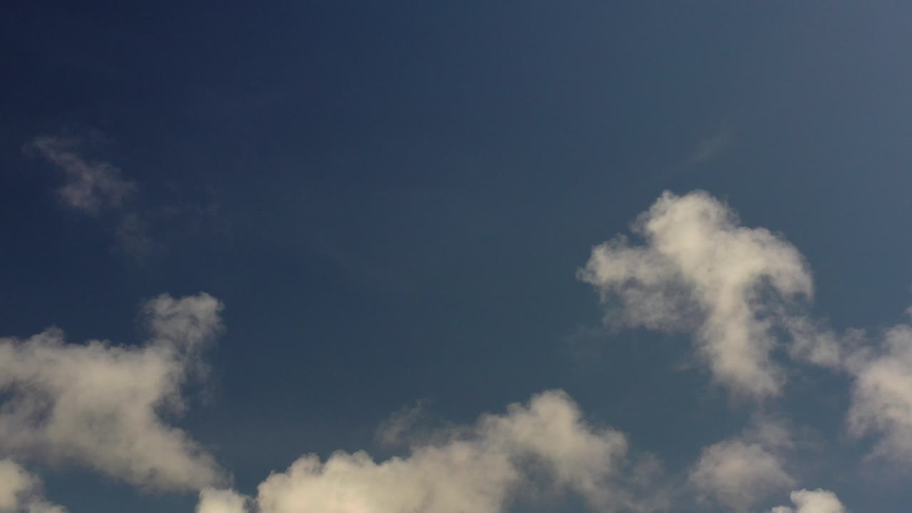 White clouds cluster along the lower edge of a deep blue sky in Los Cabos, Mexico, with no visible people.
