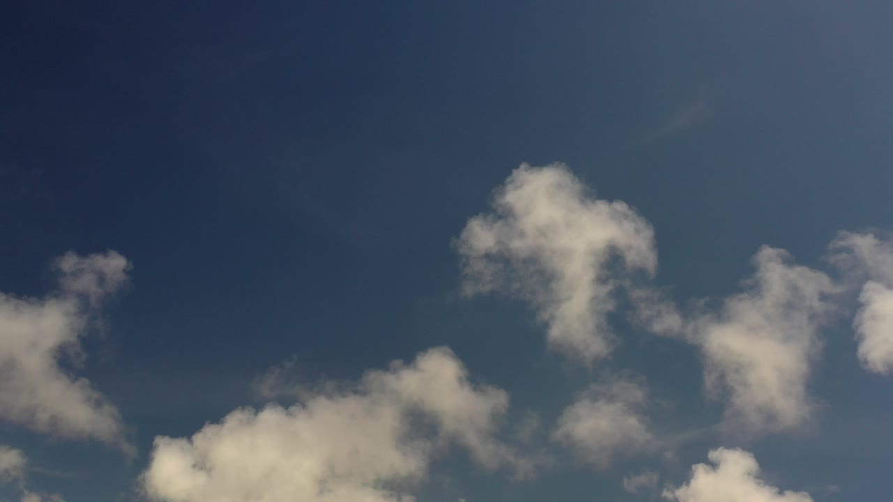 White clouds sit low and across the middle of a deep blue Los Cabos sky, with no visible people or ground features.