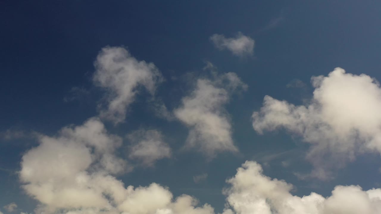 At 0:01, the Los Cabos sky view holds on white cloud clusters along the lower edge and smaller wisps above, with no visible people.