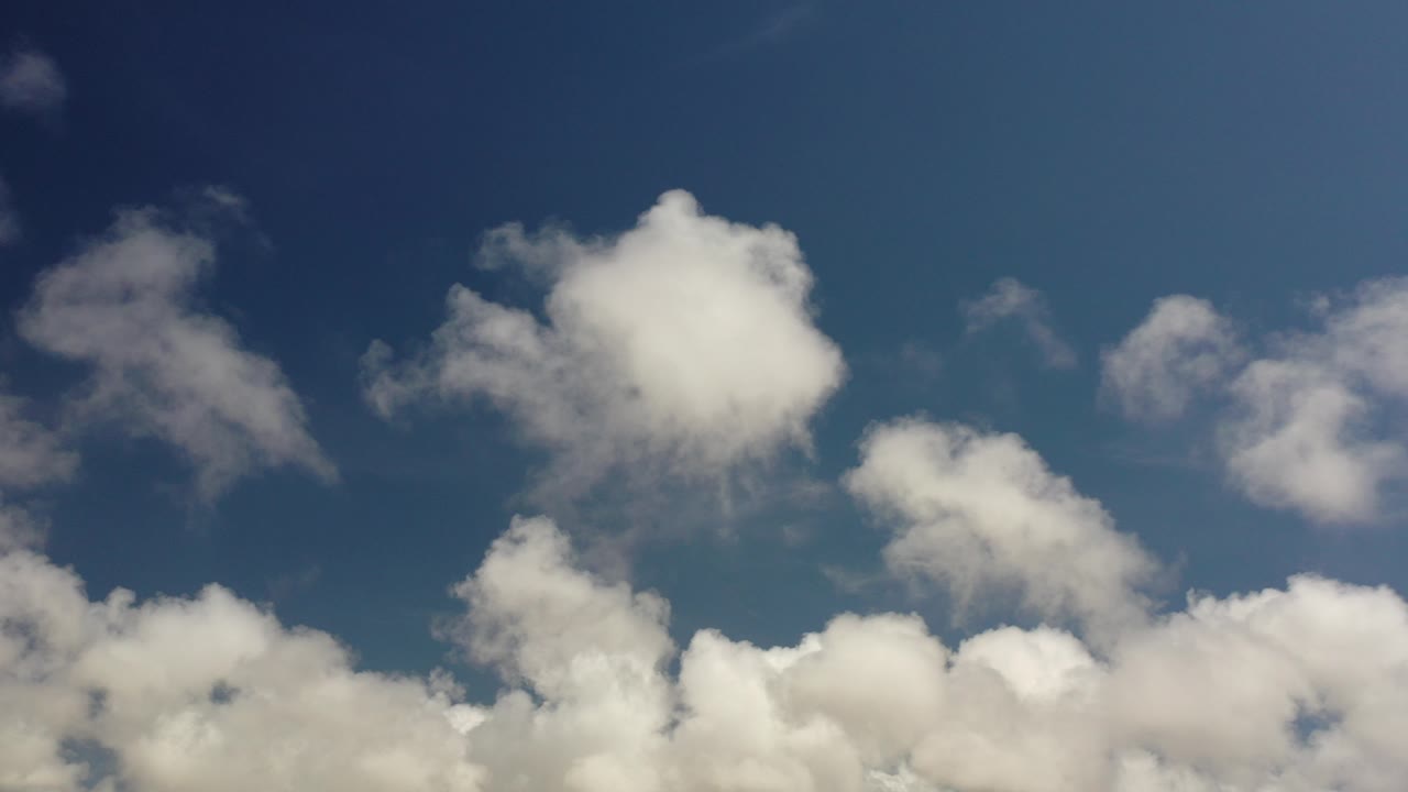 Opening frame of Los Cabos, Mexico sky with clustered white clouds along the lower edge, deeper blue overhead, and no visible people.