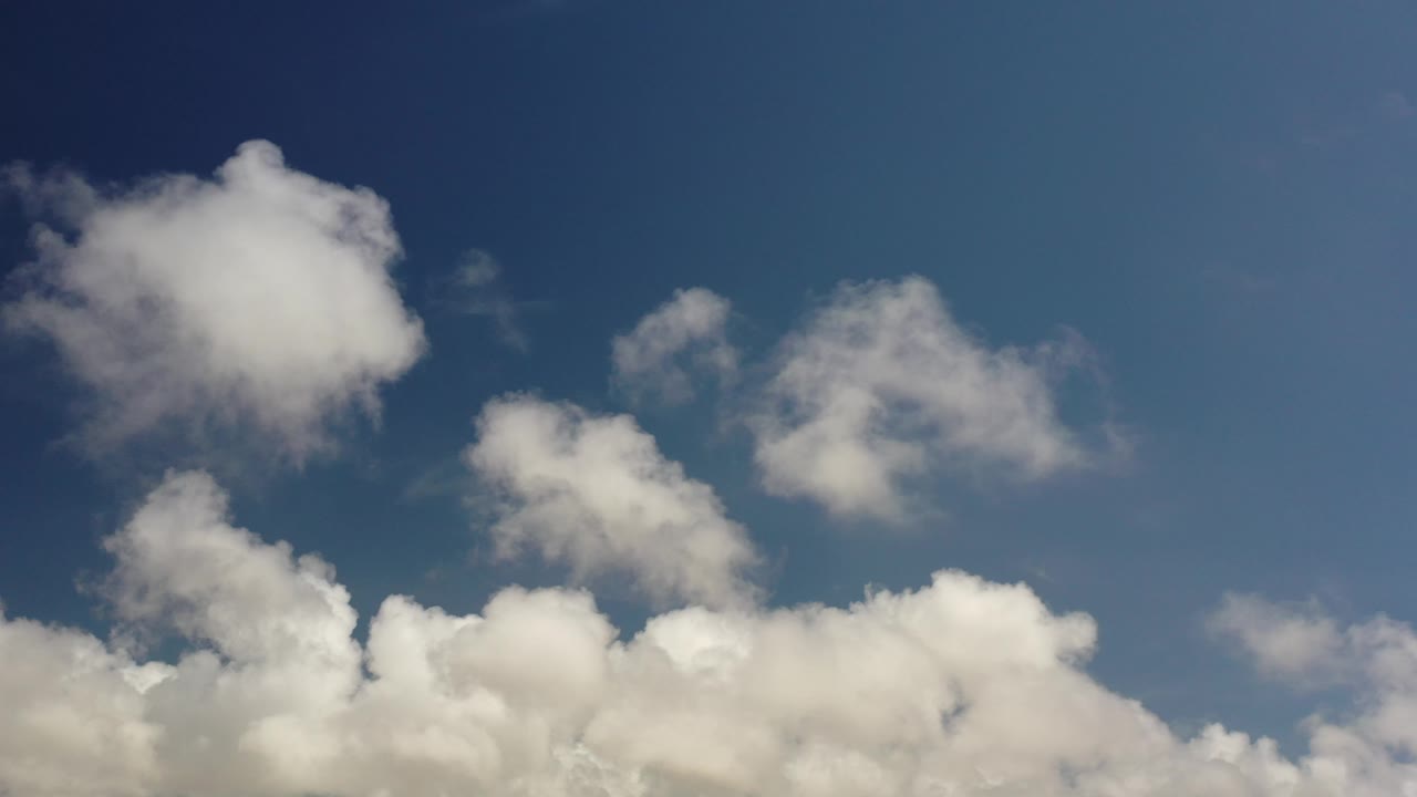 Blue sky with scattered white cloud shapes.