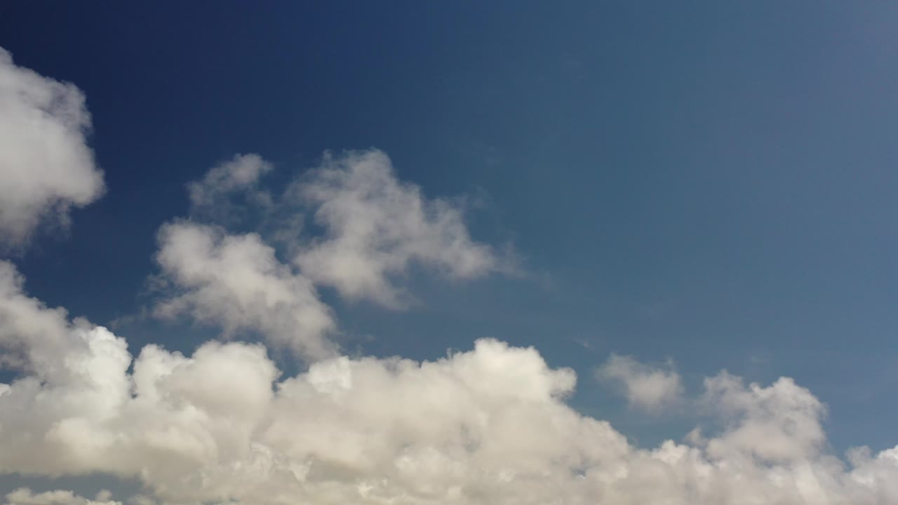 Bright white clouds spread across a clear blue sky.