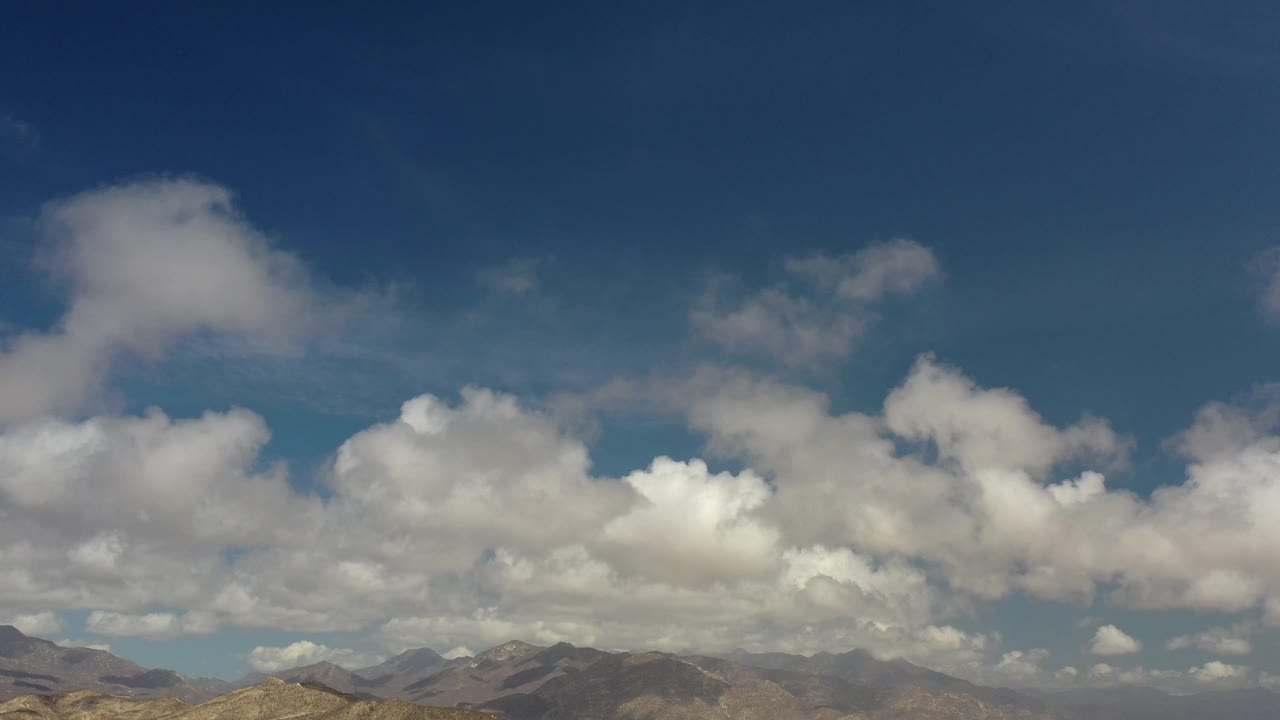 Wide sky view with clouds and far mountains.