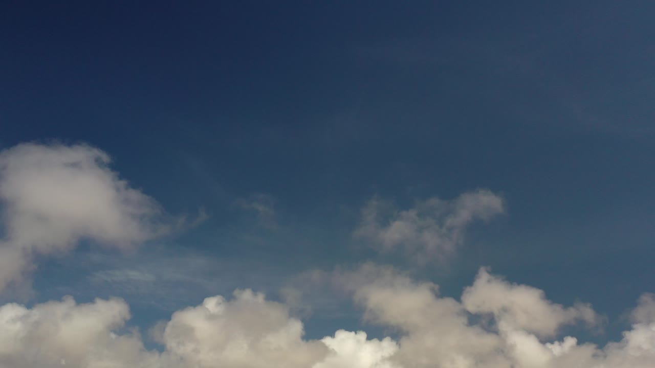 At the opening moment, white clouds line the lower edge of a deep blue Los Cabos sky with no visible people.