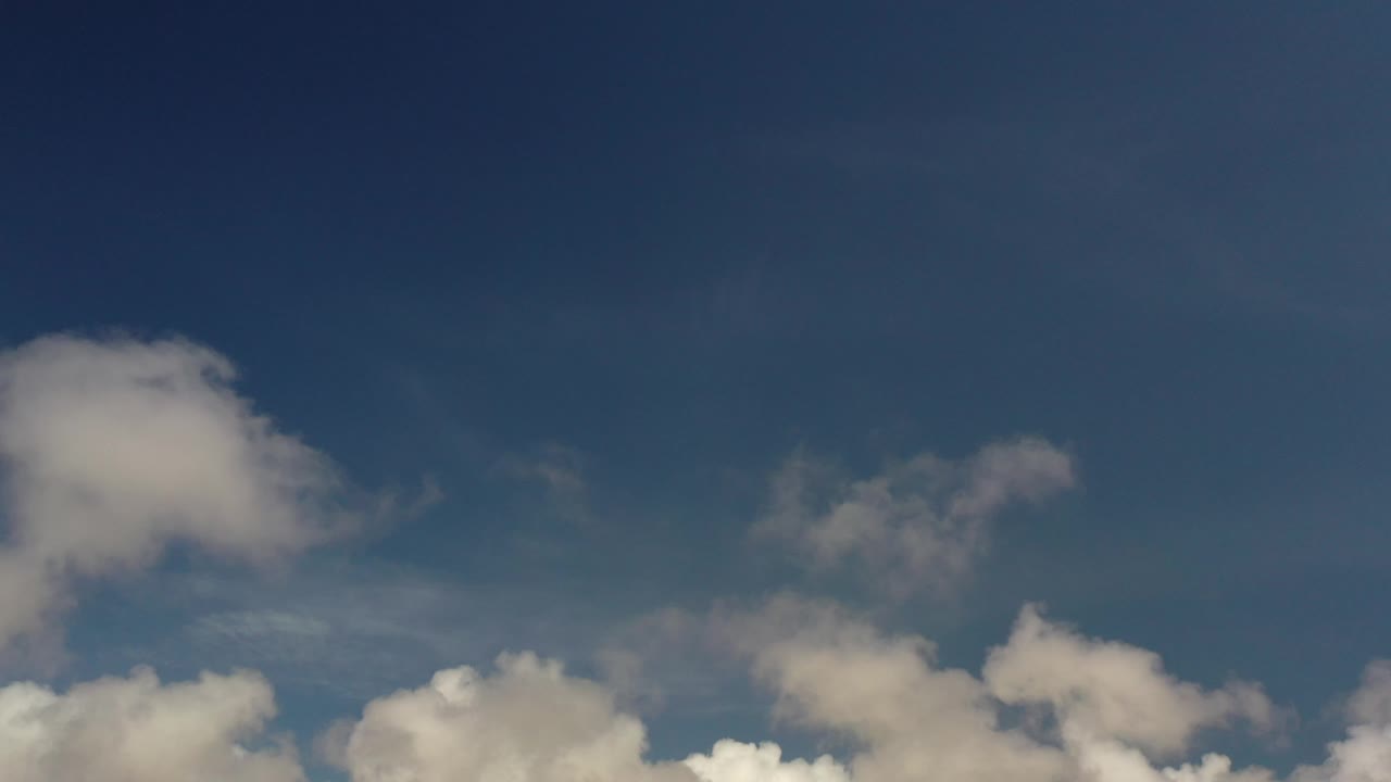 Scattered white clouds below open blue sky.