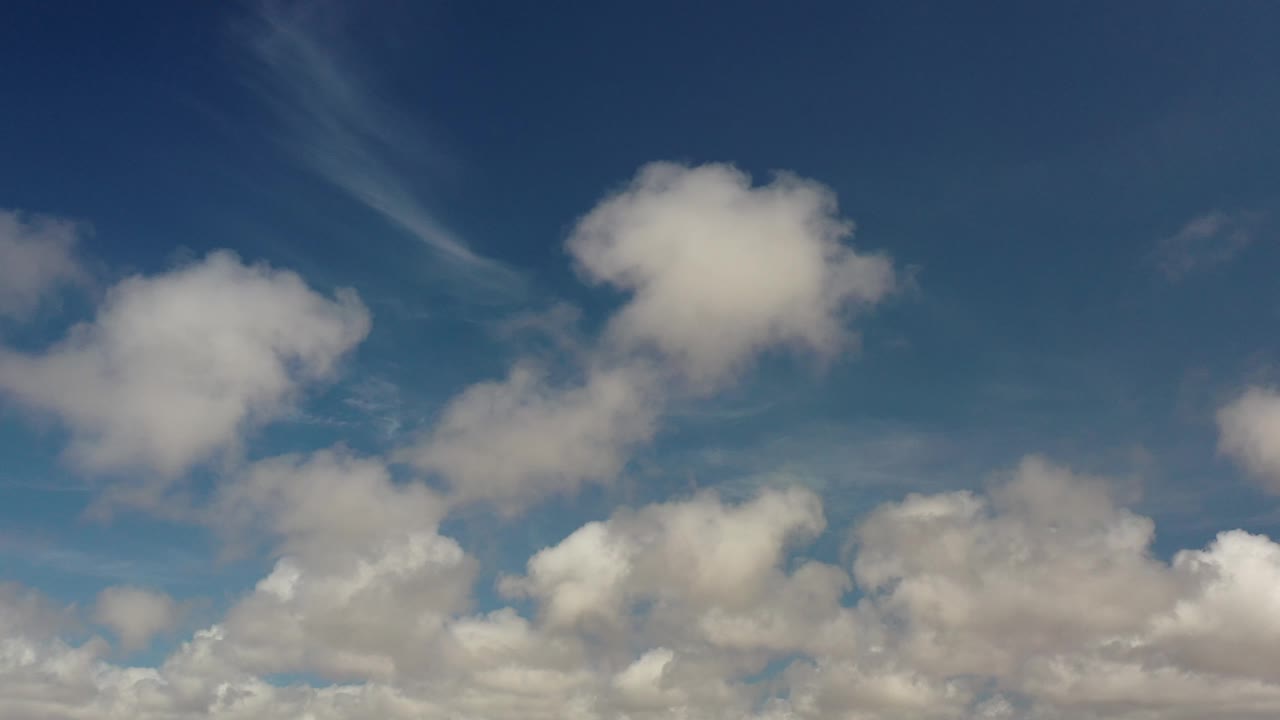 Puffy clouds against a deep blue sky.