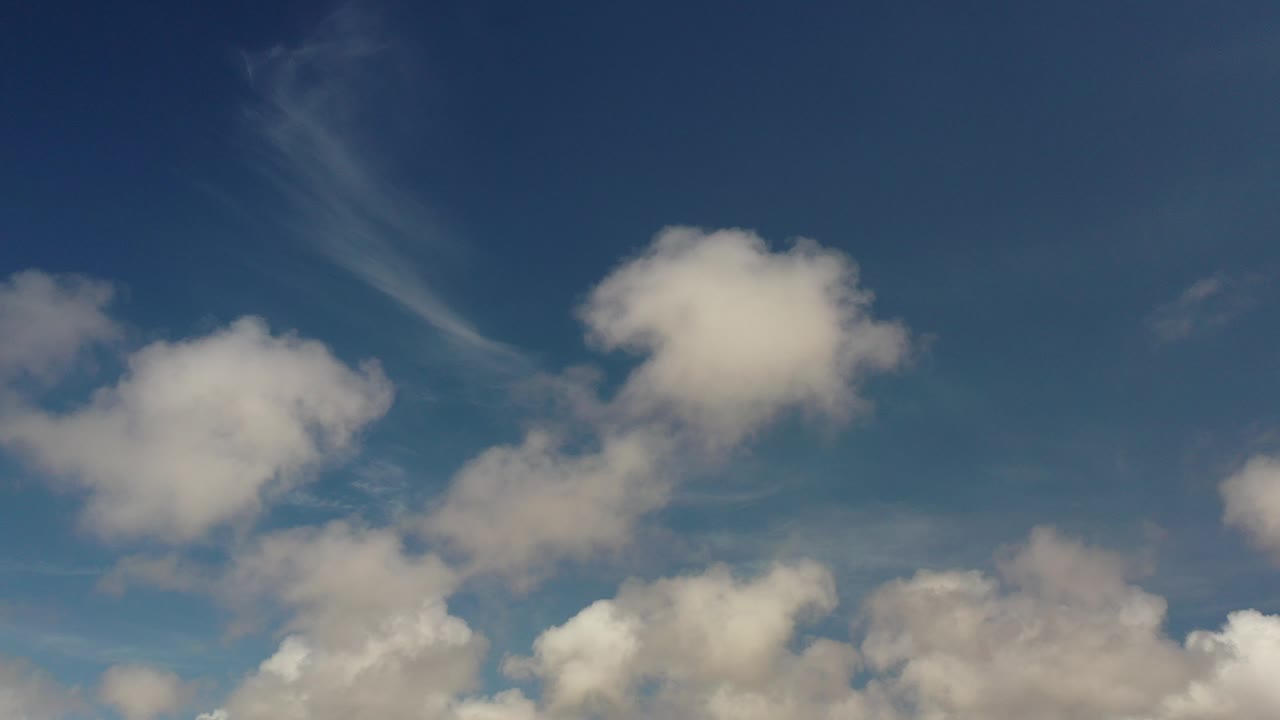 Blue Los Cabos sky with soft white clouds clustered along the lower frame and no visible people.