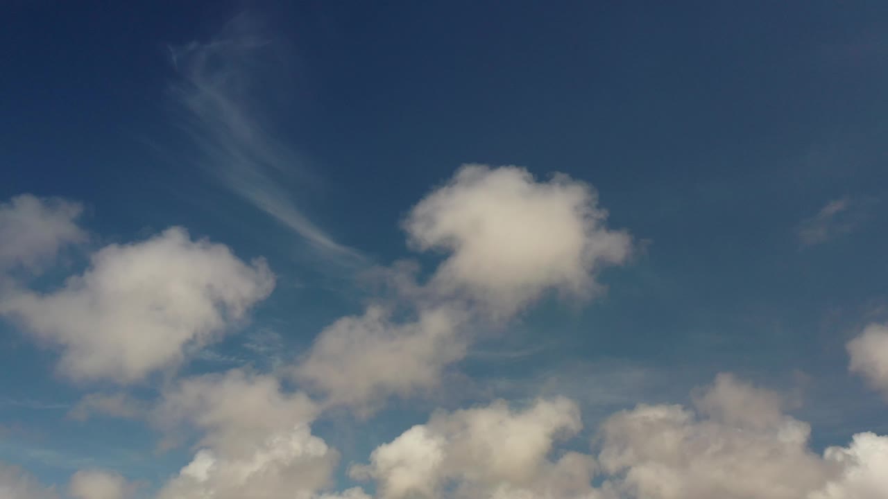 Open blue sky with white cloud clusters.